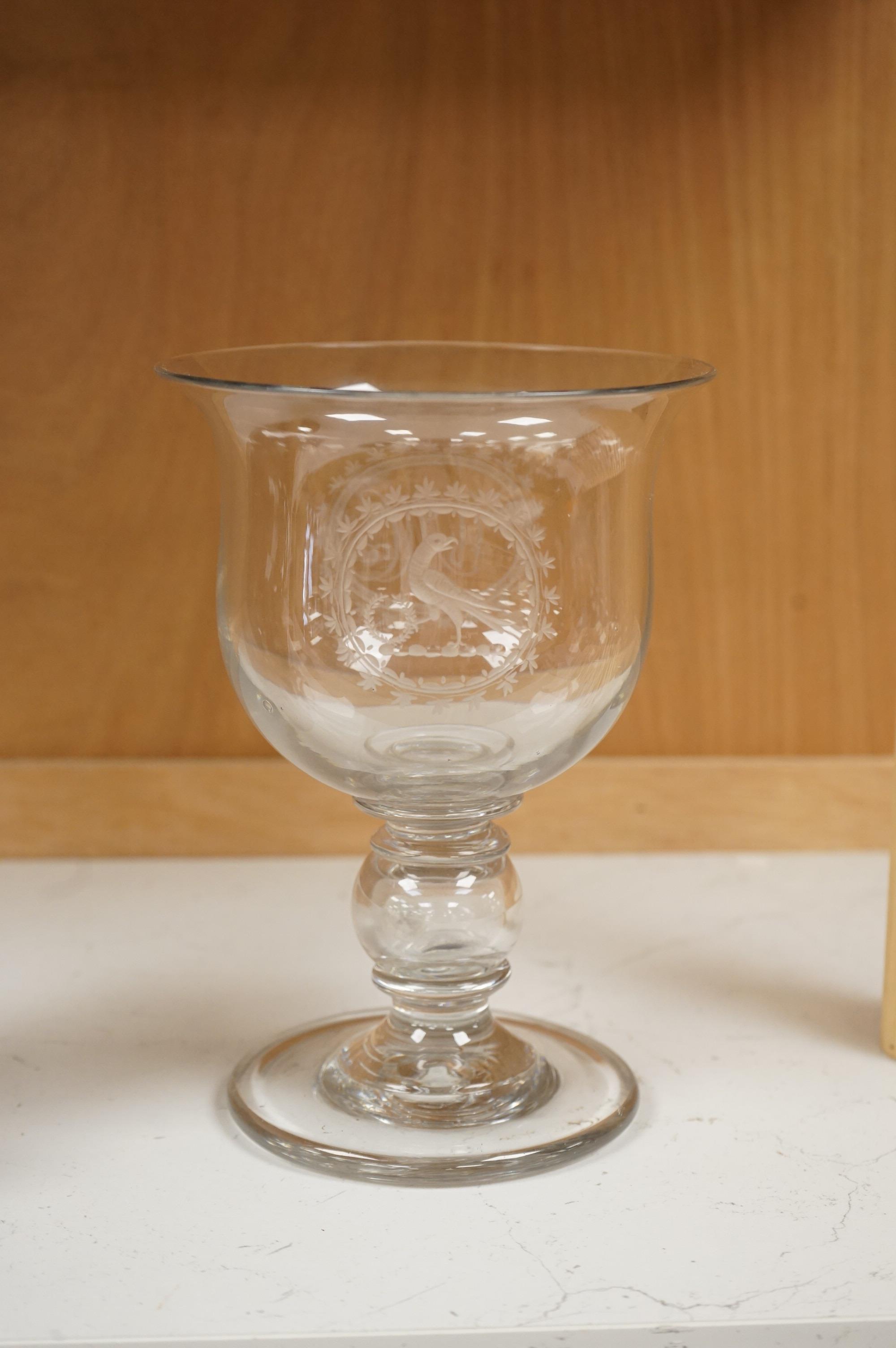 A large George III glass goblet, with inset coins to the hollow ball knopped stem, engraved with a parrot and the initials WMC, 20cm high